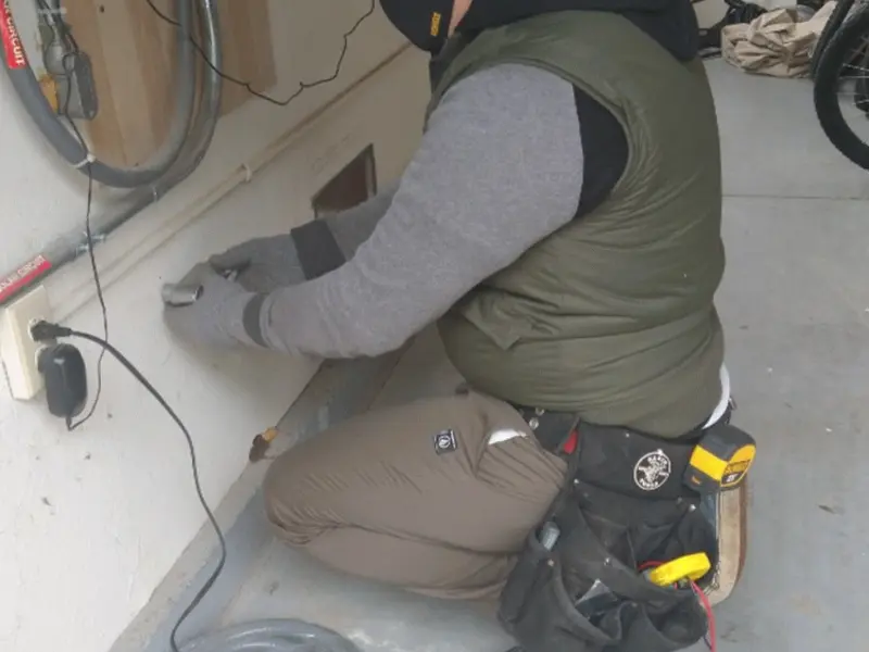 Electrician performing outlet wiring in a Coralville garage